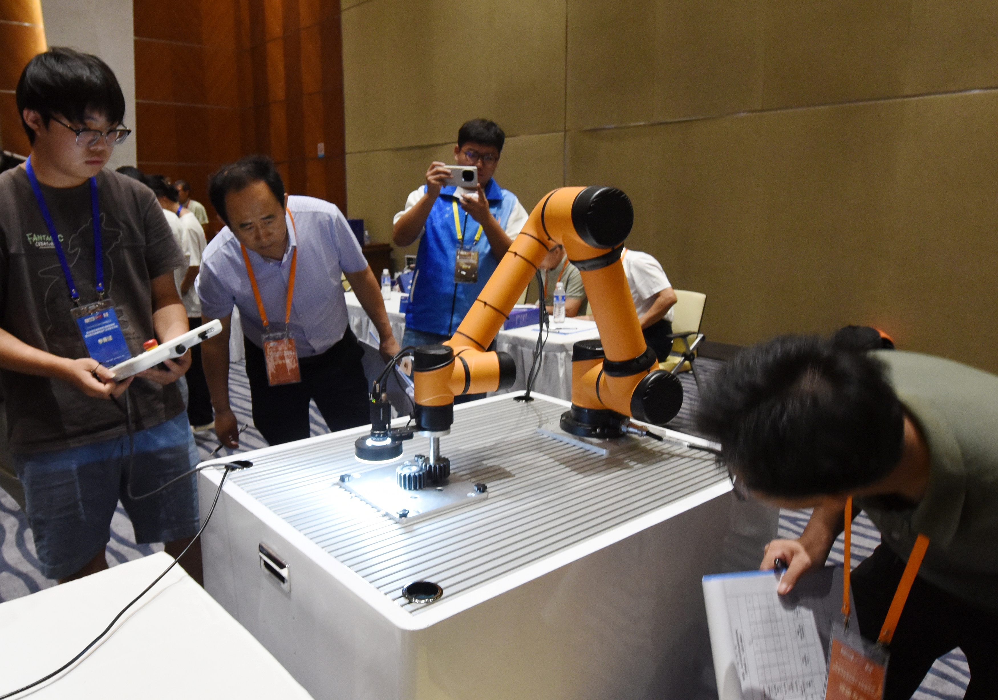 2025年中國(guó)大學(xué)生機(jī)械工程創(chuàng)新創(chuàng)意大賽智能精密裝配賽京津冀魯聯(lián)賽現(xiàn)場(chǎng)，評(píng)委對(duì)參賽選手進(jìn)行實(shí)操調(diào)試評(píng)比。